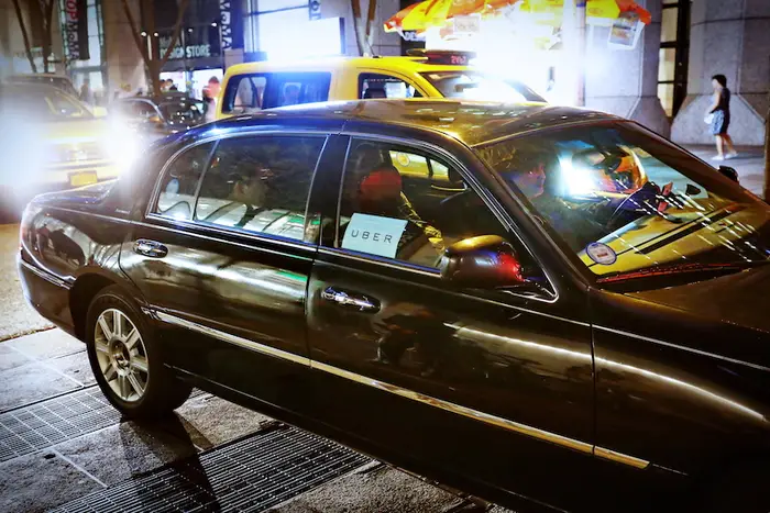 A black sedan with an Uber sign with passengers in New York City in a 2015 photo.